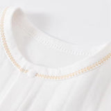 Col rond de body bébé en coton blanc, finition couture zigzag dorée – vêtement naissance haut de gamme, confortable et respirant pour climat chaud africain.