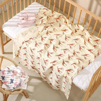 Couverture bébé motif girafe posée sur un lit à barreaux à Dakar
