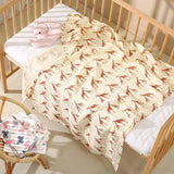 Couverture bébé motif girafe posée sur un lit à barreaux à Dakar